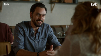 a man is talking to a woman in a restaurant