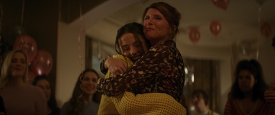 a woman is hugging another woman at a party