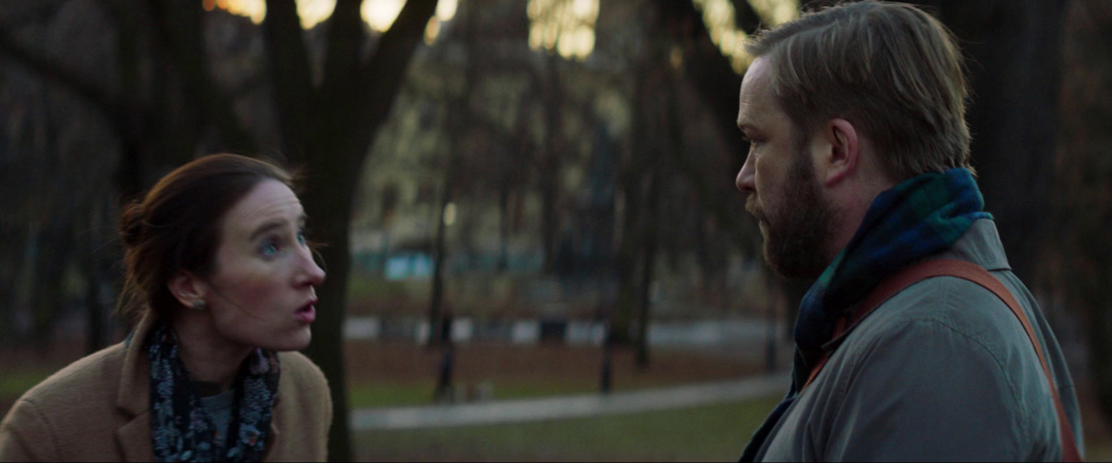 a man and woman in a park looking at each other