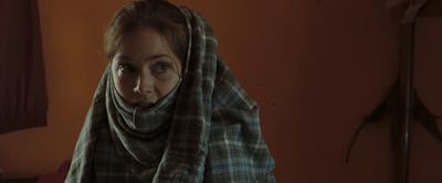 a woman wearing a plaid scarf in a room