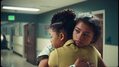 two young girls hugging each other in a hallway