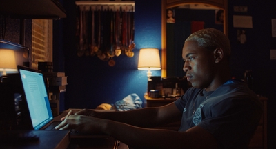 a man working on a laptop in a dark room