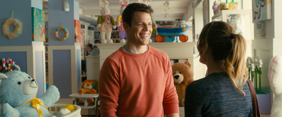 a man and woman talking in a room full of stuffed animals