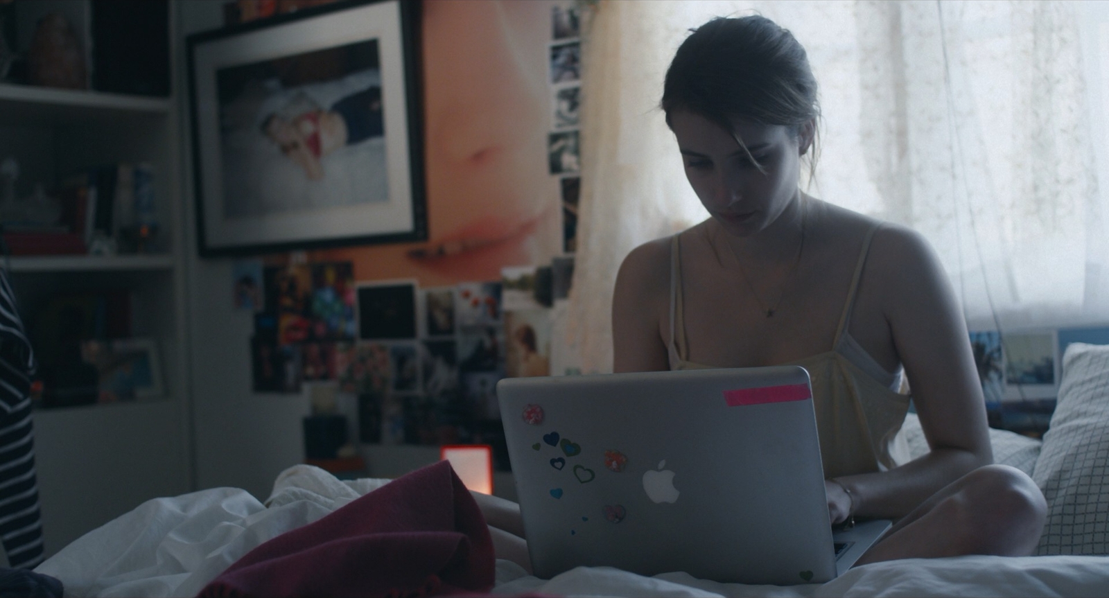 a woman sitting on a bed with a laptop