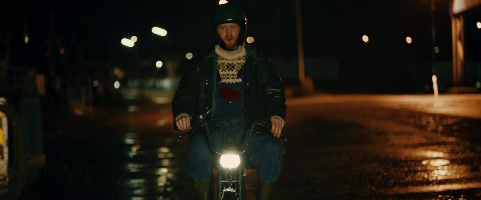 a man riding a bike in the rain at night