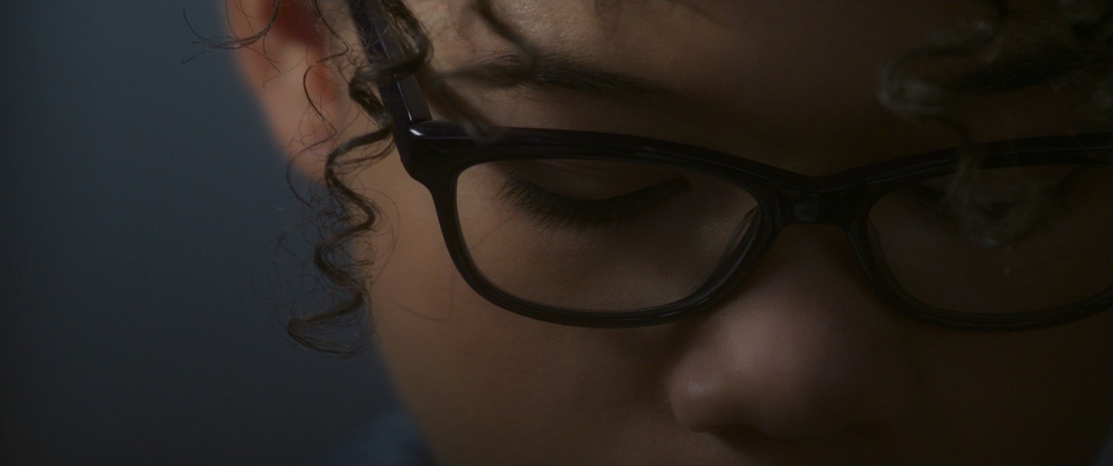 a girl with curly hair wearing glasses