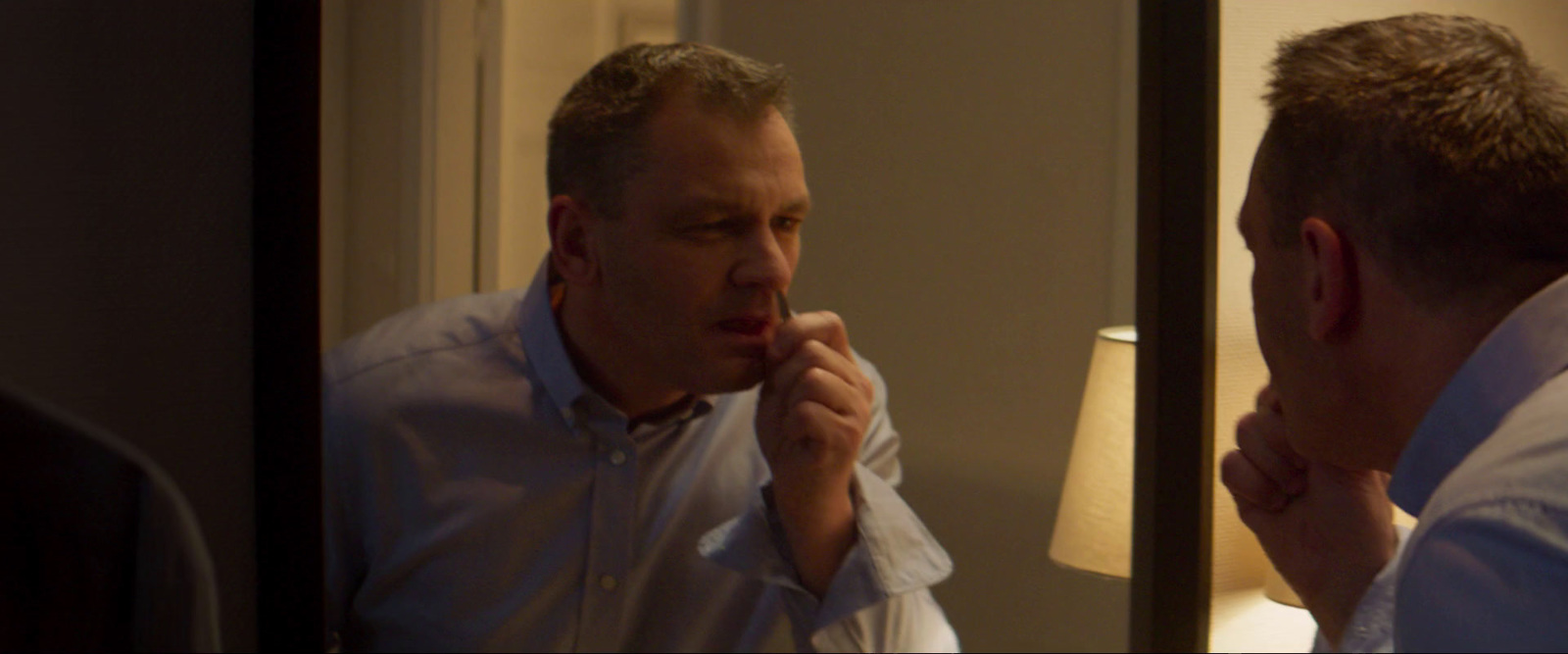 a man is brushing his teeth in front of a mirror