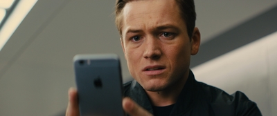 a man in a black jacket is holding a cell phone