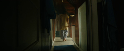 a person walking down a hallway in a dark room