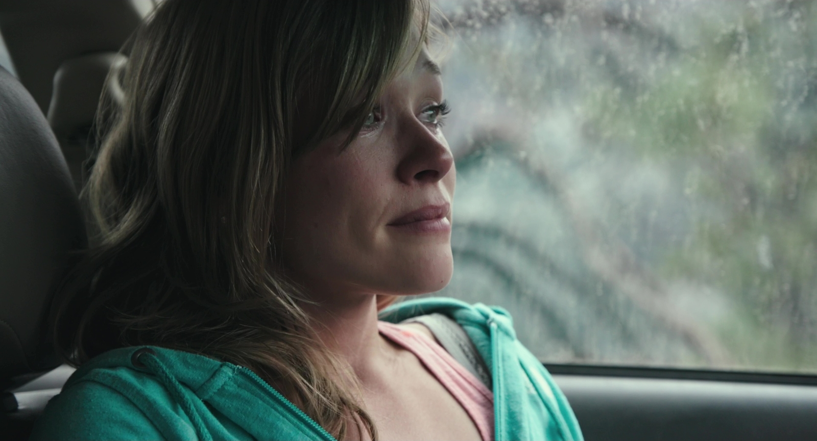 a woman sitting in a car looking out the window