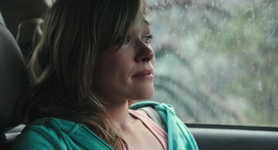 a woman sitting in a car looking out the window