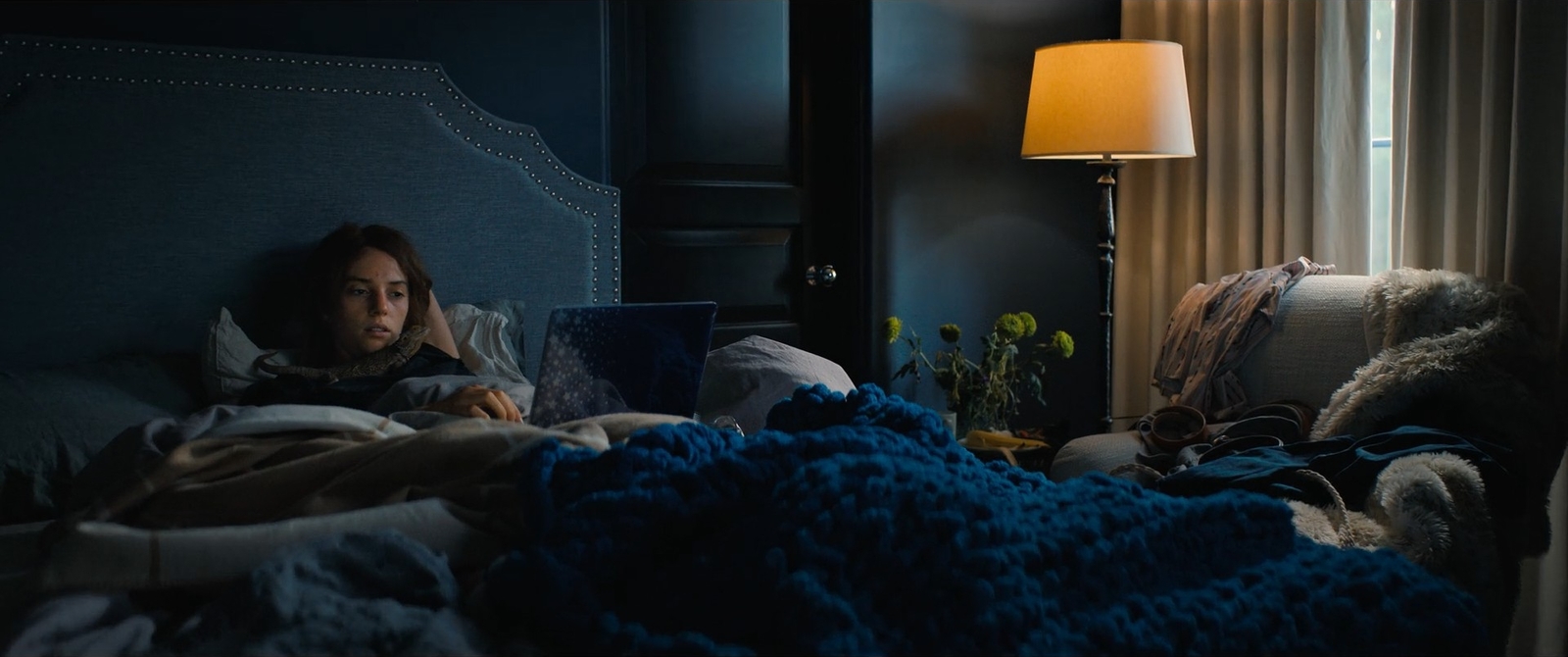 a woman laying in bed with a blanket