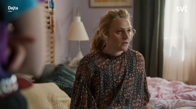 a woman is standing next to a bed in a bedroom