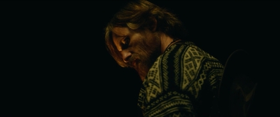 a man in a dark room with his head down