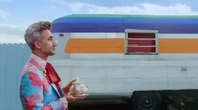 a man in a colorful suit holding a jar