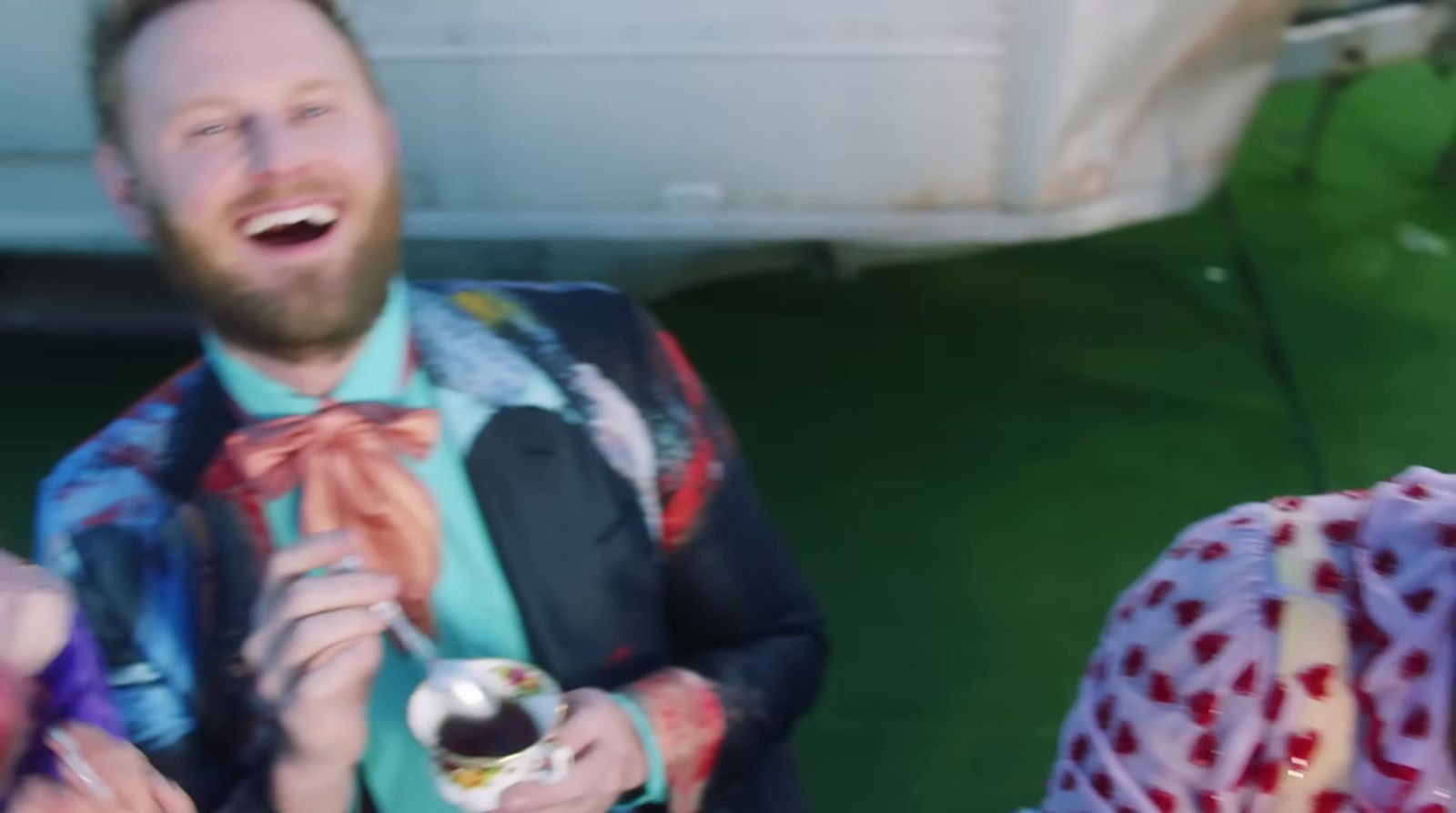 a man in a suit and bow tie holding a drink