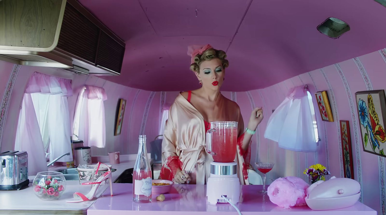 a woman standing in a kitchen next to a blender