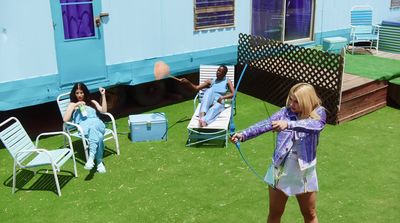 a woman in a purple shirt is playing with a frisbee