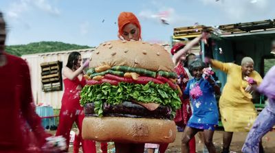 a giant hamburger is being carried by a group of people