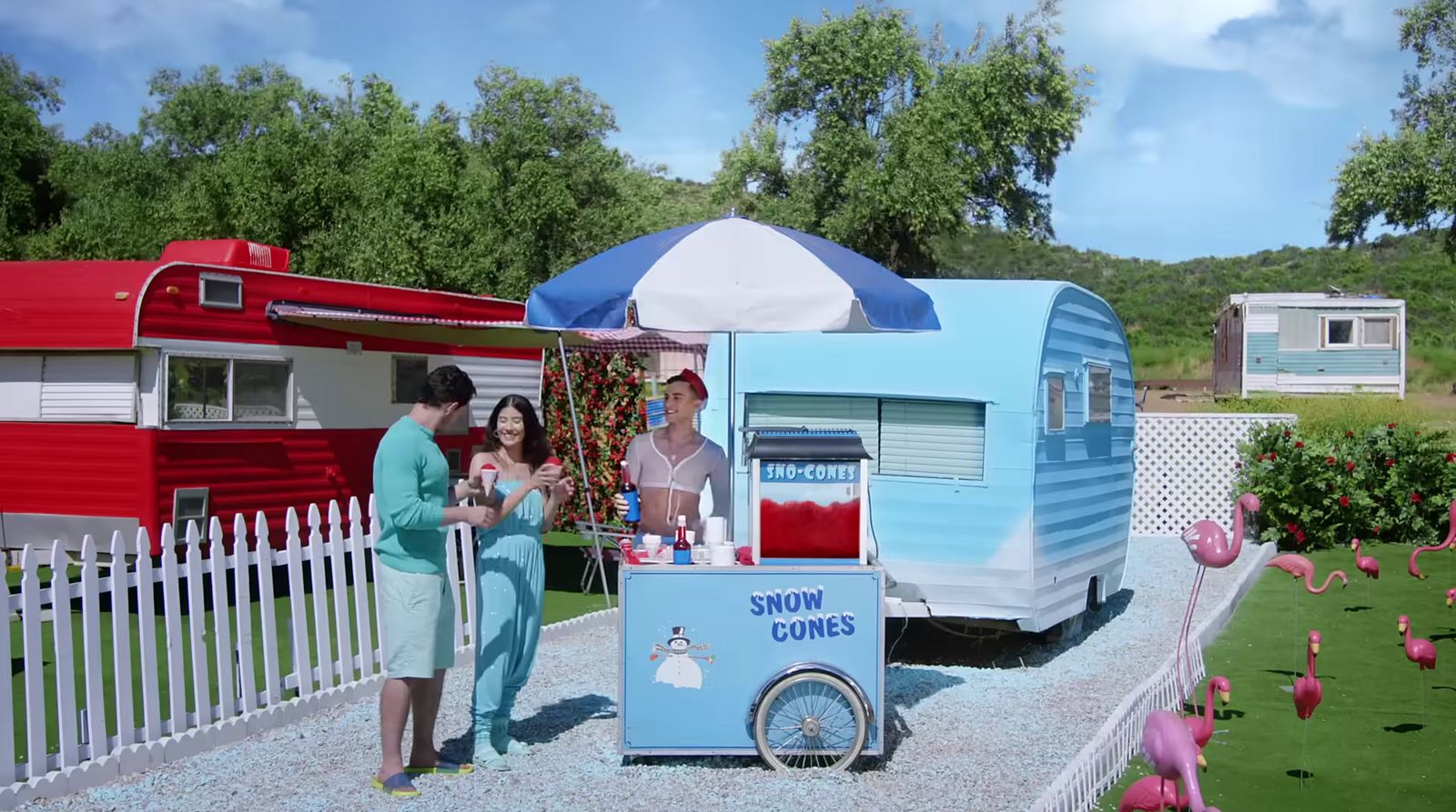 a woman and a man standing in front of a trailer