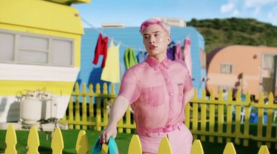 a man in a pink outfit holding a blue frisbee