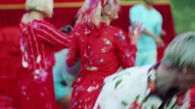 a blurry photo of a group of women in red dresses