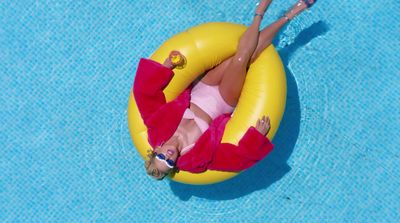 a woman laying on a raft in a pool