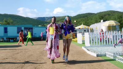 a couple of women walking down a dirt road