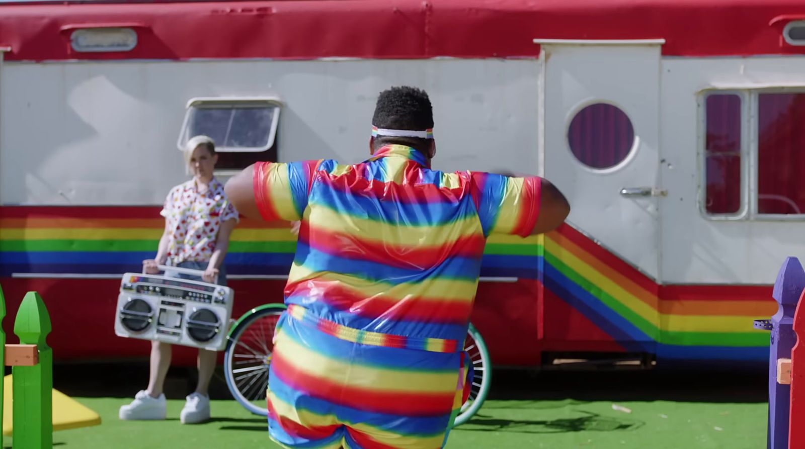 a man in a clown suit standing in front of a trailer