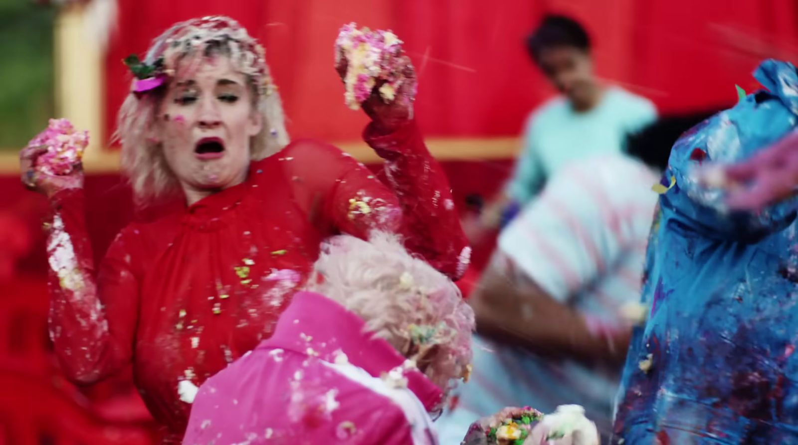 a woman in a red dress covered in colored powder