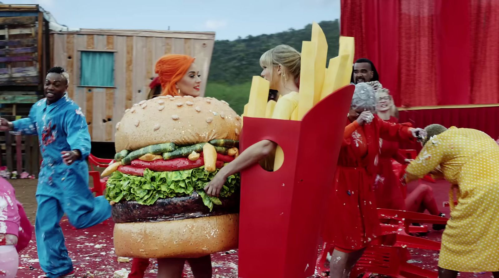 a group of people standing around a giant hamburger