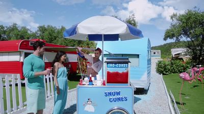 a man and a woman standing in front of a snow cone