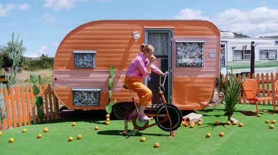 a woman riding a bike next to a trailer