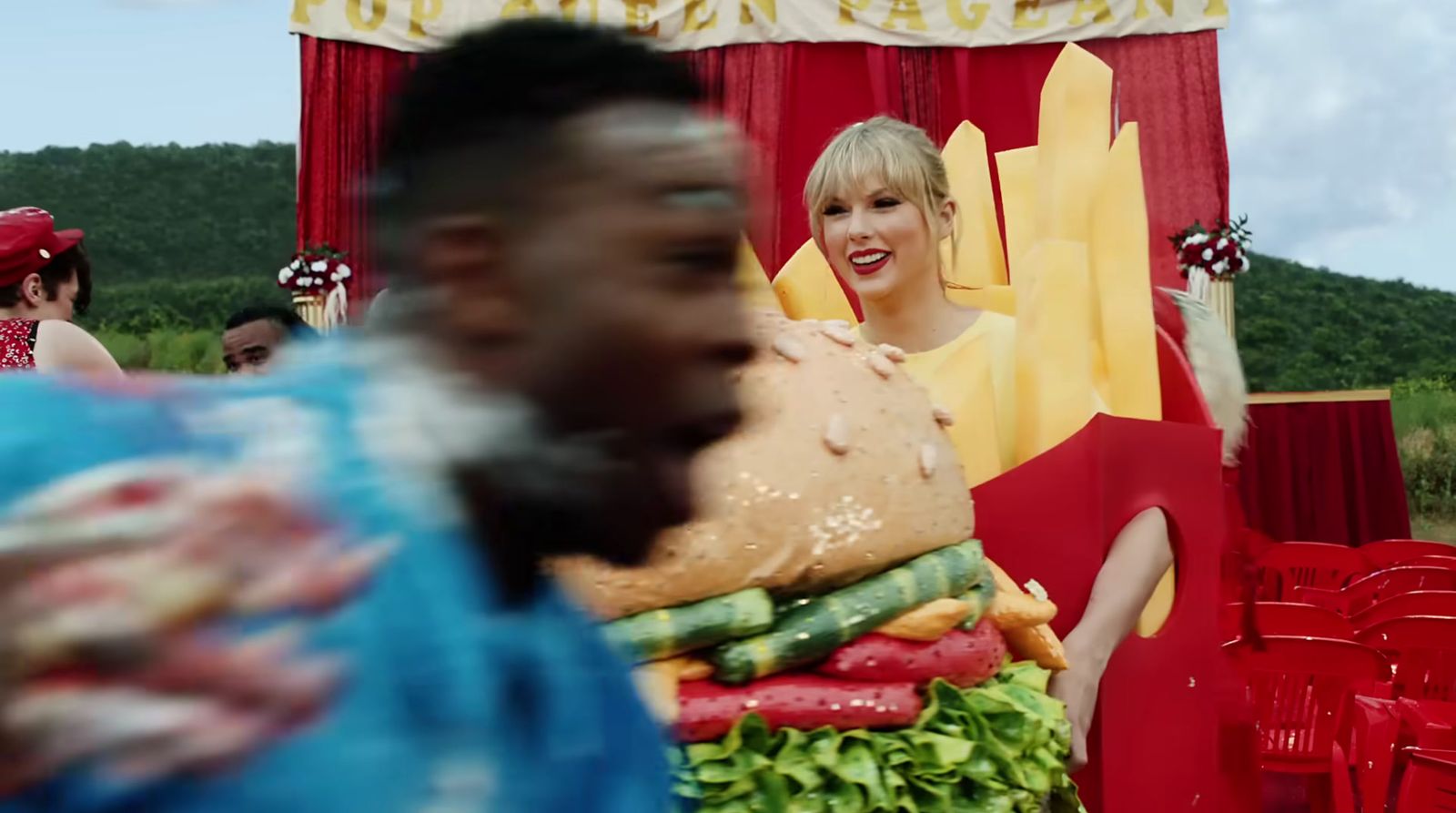 a woman standing in front of a giant hamburger