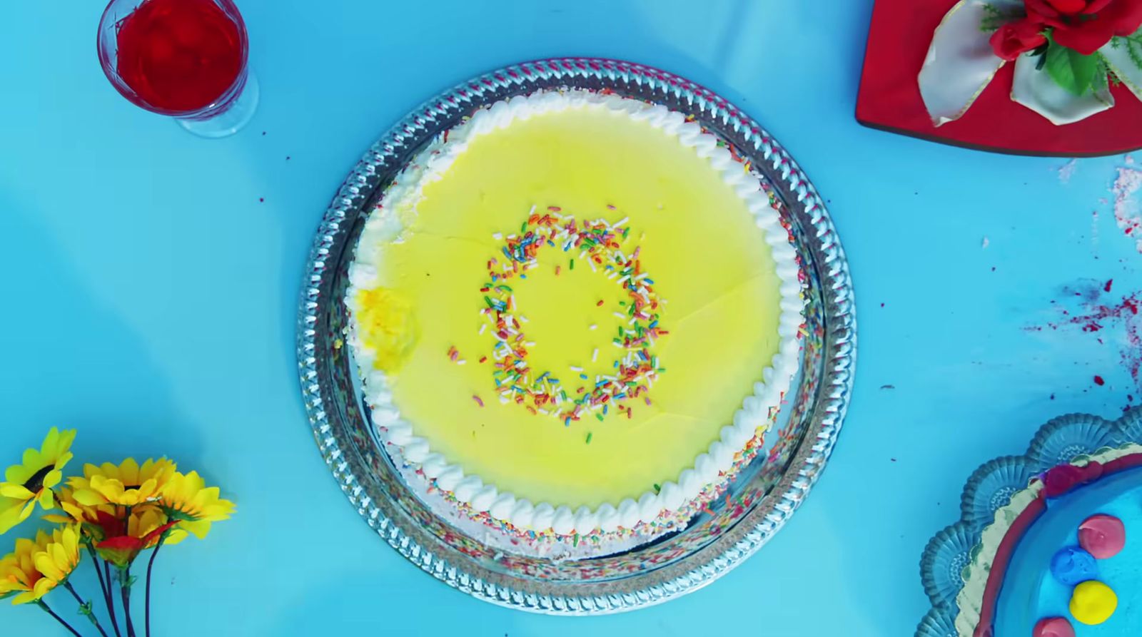 a birthday cake with sprinkles on a blue table