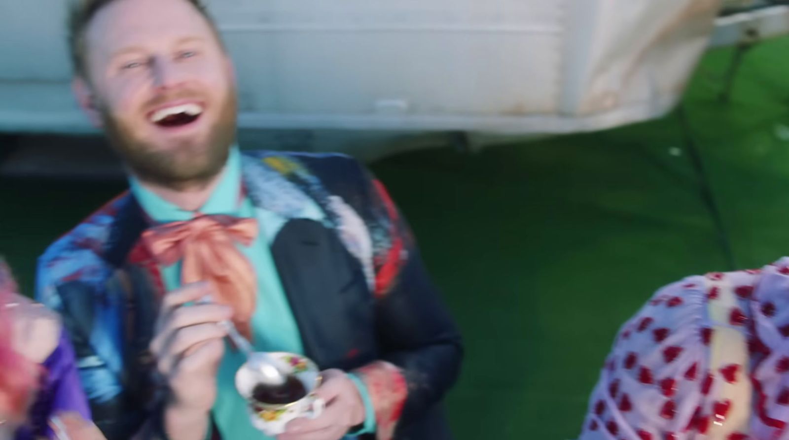 a man in a suit and tie holding a bottle of beer