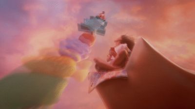 a man sitting on top of a giant object in the sky
