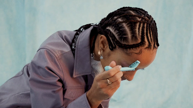 a woman brushing her teeth with a toothbrush