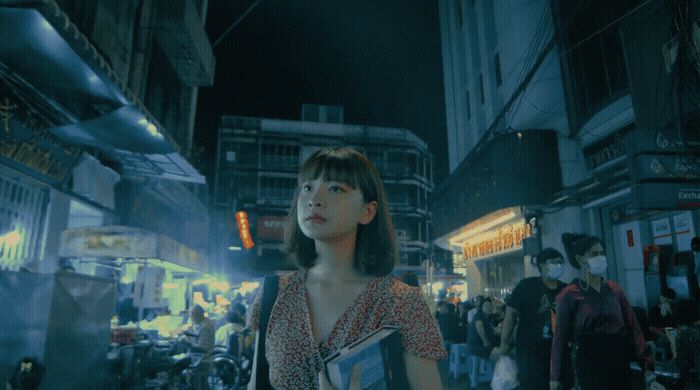 a woman standing in the middle of a crowded street