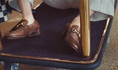 a person sitting on a chair with a pair of shoes