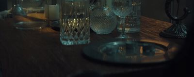 a wooden table topped with glass vases and candles