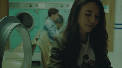 a woman sitting in front of a dryer next to a dryer