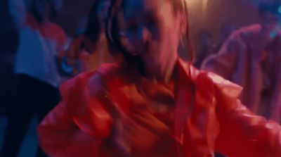 a woman in a red shirt is dancing