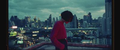 a man standing on top of a building next to a city