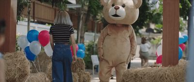 a woman standing next to a giant teddy bear