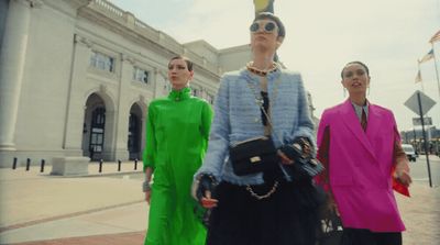 a group of women walking down a street next to a building