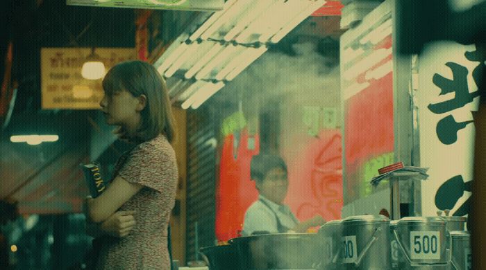 a woman standing in front of a food stand