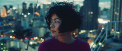 a woman standing in front of a city at night