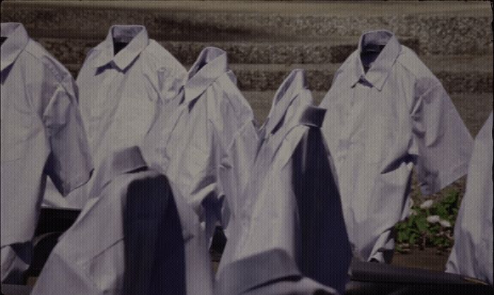 a group of white shirts hanging on a clothes line