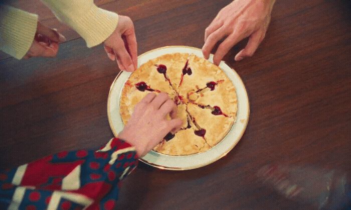 a person cutting a pie with a knife